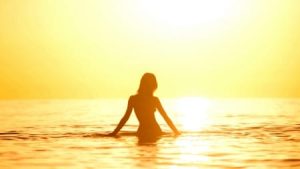 Woman at the beach at sunset
